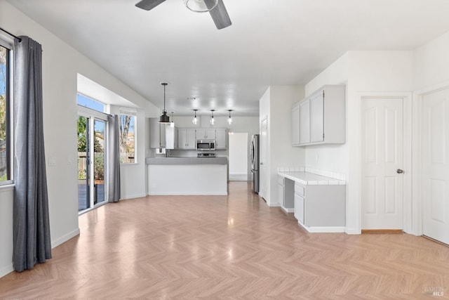 unfurnished living room with baseboards and ceiling fan