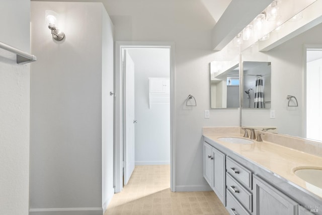 bathroom featuring a sink, baseboards, and double vanity