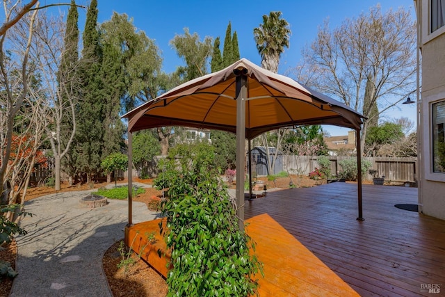 wooden terrace featuring a gazebo, fence, and an outdoor fire pit