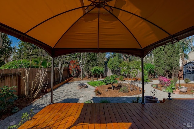 deck featuring a gazebo, an outdoor fire pit, and fence