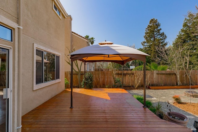 wooden terrace featuring a gazebo and fence