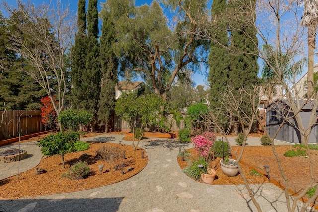 view of yard featuring an outdoor fire pit and fence