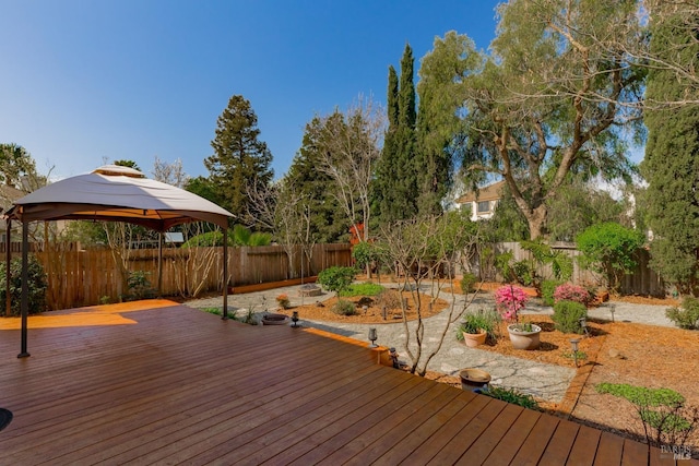 deck with a gazebo, a garden, and a fenced backyard