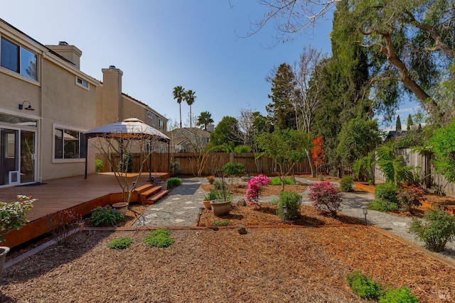 view of yard featuring a gazebo, a wooden deck, and a fenced backyard