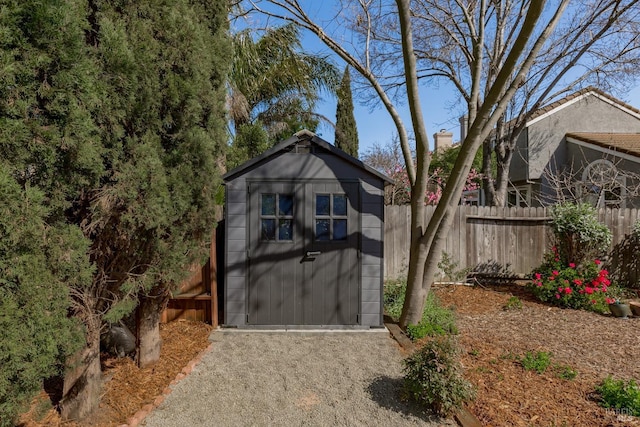 view of shed with a garage and fence