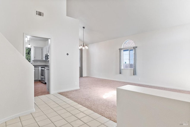 empty room with light tile patterned floors, visible vents, baseboards, an inviting chandelier, and light carpet