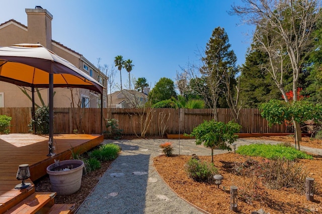 view of yard featuring a gazebo, a wooden deck, and a fenced backyard