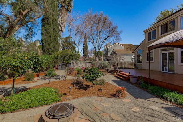 view of yard with a fenced backyard, a patio area, a deck, and an outdoor fire pit