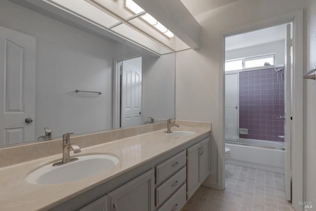 full bathroom with a sink, shower / bathtub combination, toilet, and double vanity