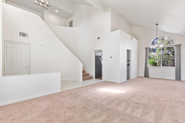 unfurnished living room with visible vents, high vaulted ceiling, a notable chandelier, stairway, and carpet