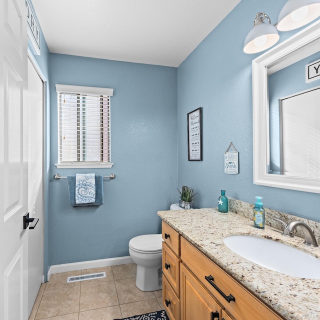 bathroom featuring vanity, baseboards, visible vents, tile patterned floors, and toilet