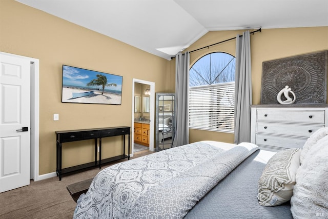 bedroom featuring baseboards, carpet floors, lofted ceiling, and ensuite bathroom