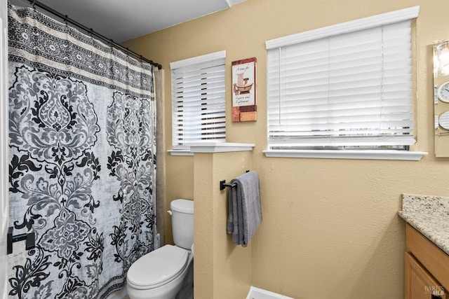 bathroom featuring vanity, a shower with shower curtain, and toilet