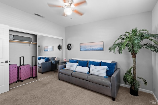 living room featuring carpet flooring, a ceiling fan, visible vents, and baseboards