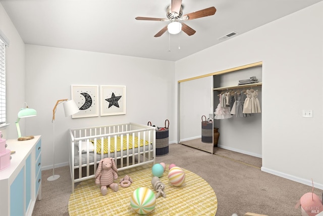 bedroom featuring a closet, visible vents, a crib, and carpet