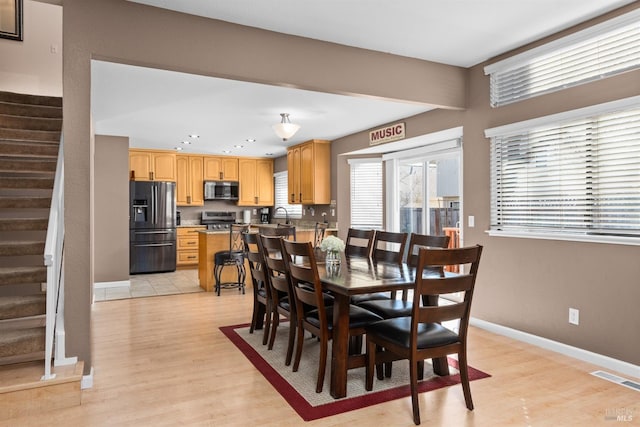 dining room with light wood-type flooring, visible vents, recessed lighting, baseboards, and stairs