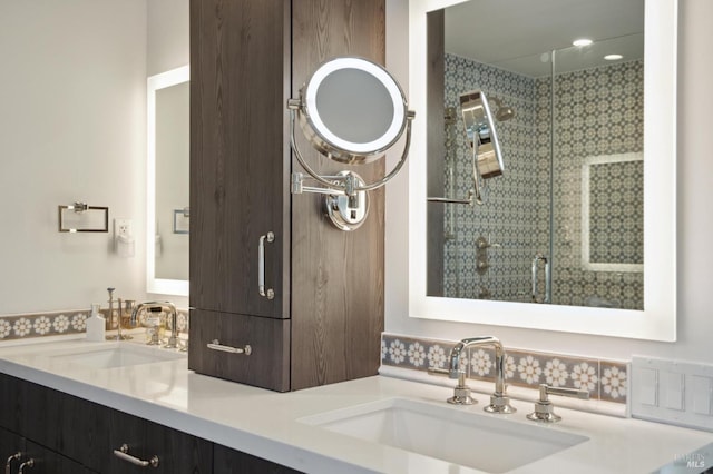 bathroom with double vanity, a sink, and a shower stall