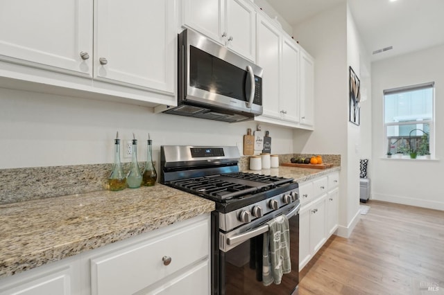 kitchen featuring visible vents, appliances with stainless steel finishes, white cabinets, and light wood finished floors