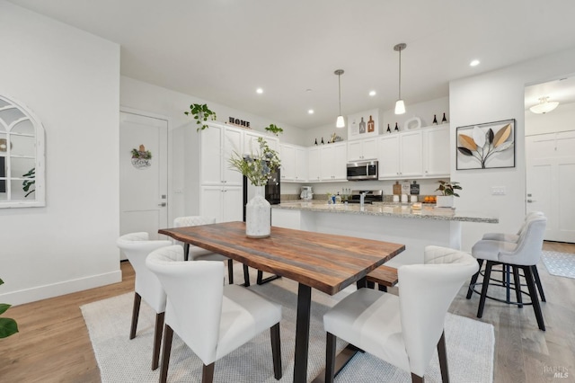 dining space featuring recessed lighting, baseboards, and light wood finished floors