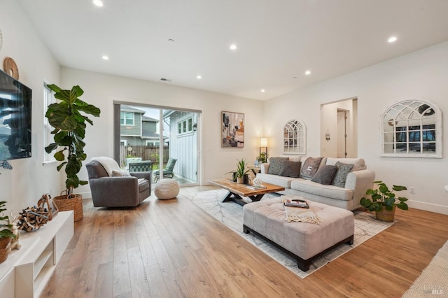 living room with recessed lighting, baseboards, wood-type flooring, and visible vents