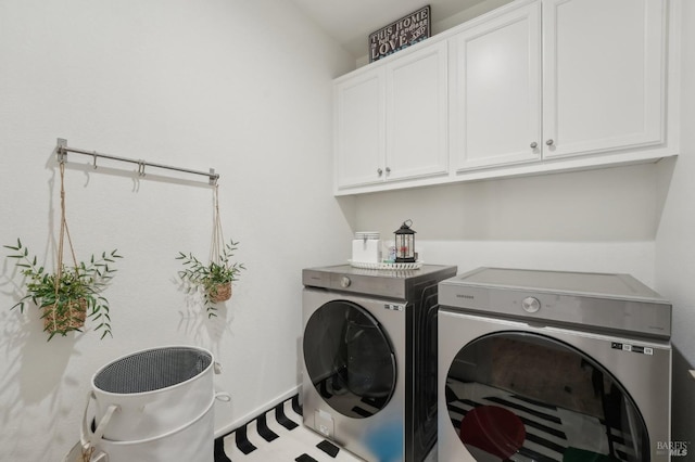 clothes washing area with washing machine and clothes dryer and cabinet space