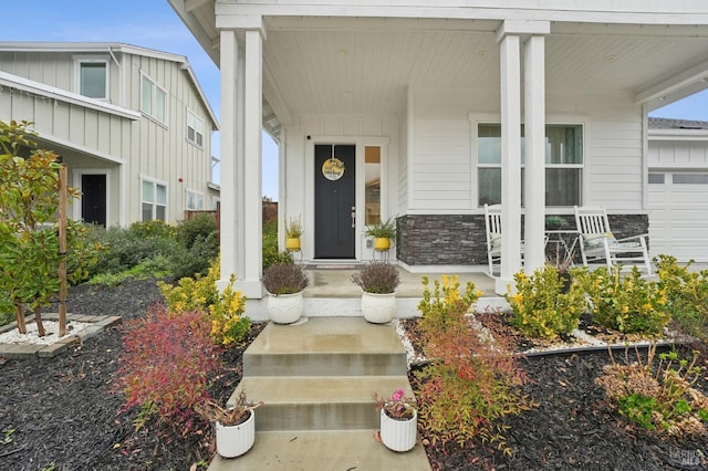 view of exterior entry featuring a porch and stone siding