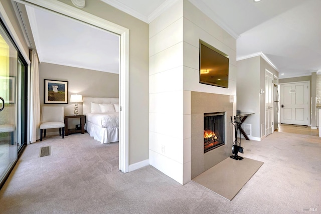 carpeted living room with visible vents, a fireplace with flush hearth, baseboards, and crown molding