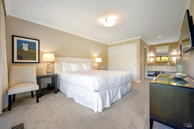 bedroom featuring visible vents, crown molding, baseboards, light colored carpet, and a closet