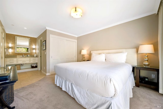 bedroom featuring a sink, ornamental molding, a closet, and light carpet