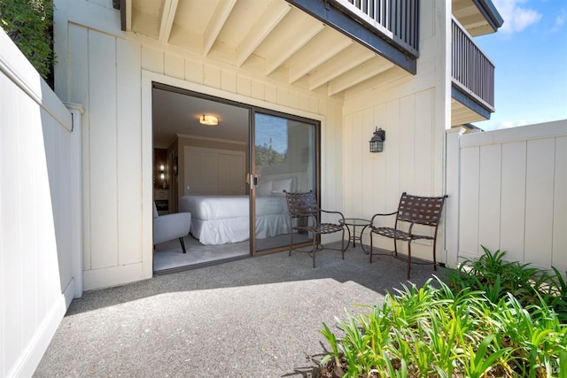 view of patio featuring a balcony and fence