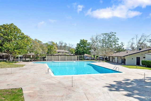 pool with a patio area and fence