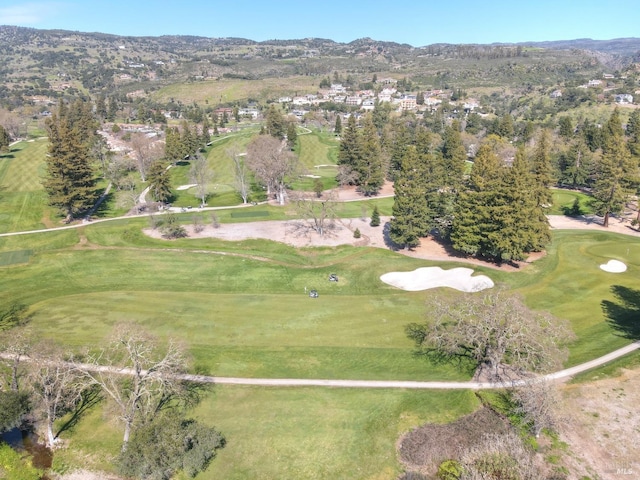 drone / aerial view with golf course view and a mountain view