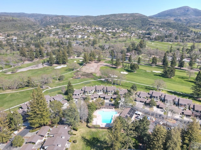 drone / aerial view with a mountain view, golf course view, and a residential view