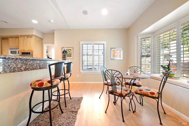 dining area featuring recessed lighting, light wood-style flooring, and baseboards