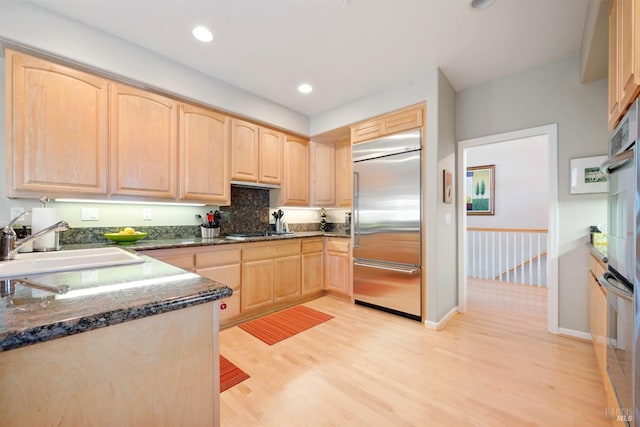 kitchen with a sink, light wood-style flooring, light brown cabinets, and stainless steel appliances