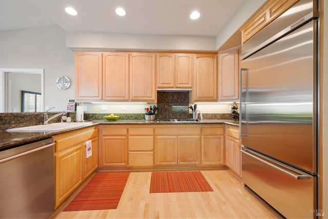 kitchen featuring a sink, stainless steel appliances, light wood-style flooring, and light brown cabinetry