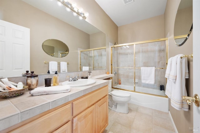 bathroom with vanity, visible vents, tile patterned flooring, toilet, and combined bath / shower with glass door