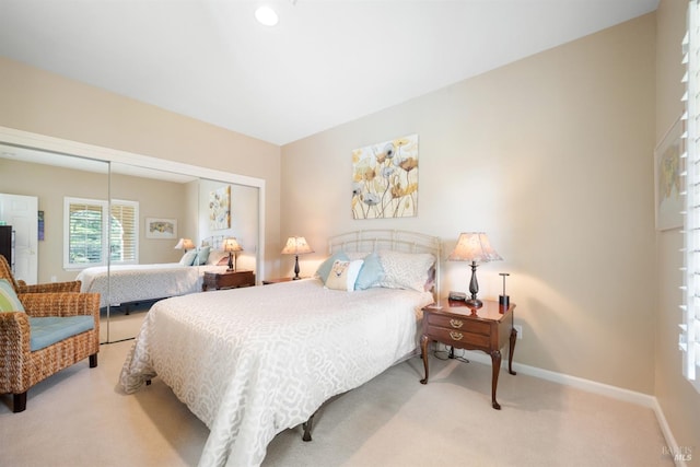 carpeted bedroom featuring baseboards and a closet