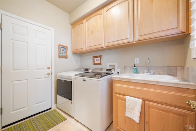 laundry room featuring cabinet space, washer and dryer, and a sink