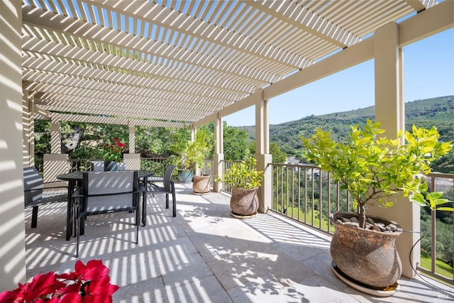 view of patio with outdoor dining area, a mountain view, and a pergola