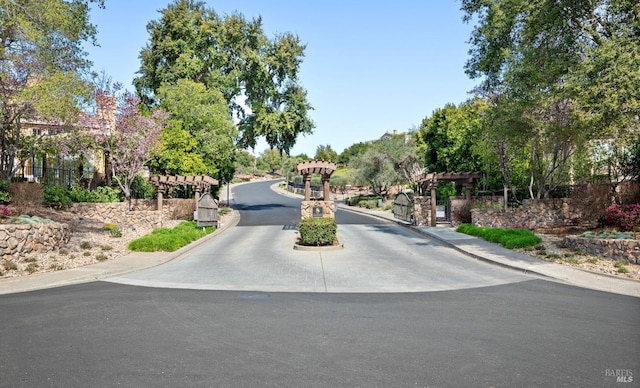 view of street featuring curbs and a gated entry