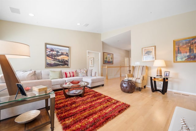 living area featuring visible vents, wood finished floors, recessed lighting, baseboards, and lofted ceiling