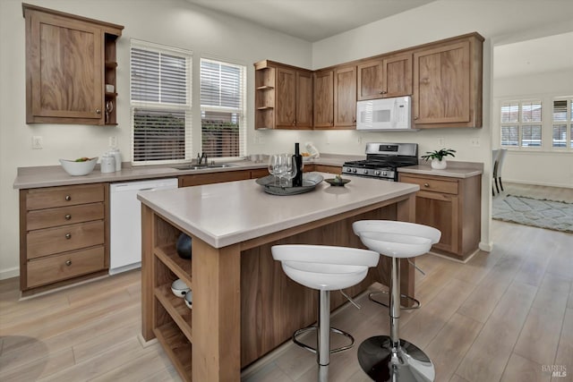 kitchen featuring open shelves, light wood-type flooring, white appliances, and a kitchen island