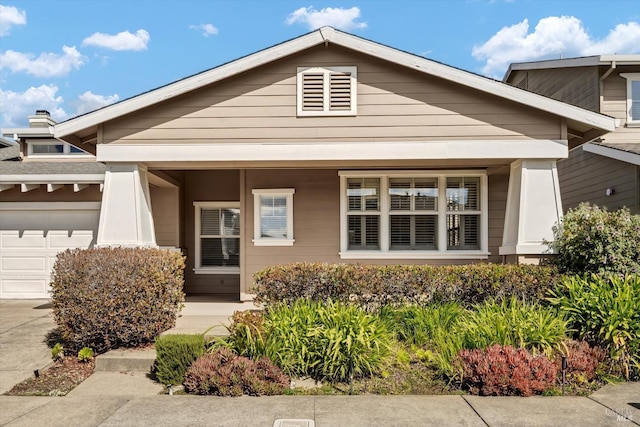 view of front facade with covered porch, an attached garage, and concrete driveway