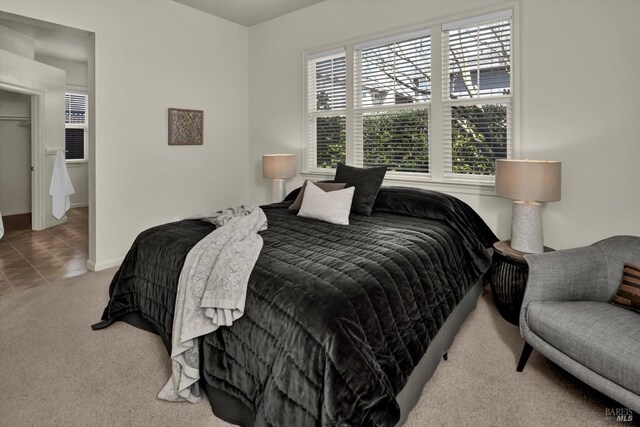 carpeted bedroom featuring tile patterned flooring and baseboards