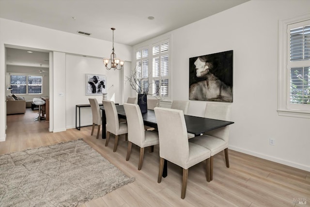 dining room featuring plenty of natural light, an inviting chandelier, and wood finished floors