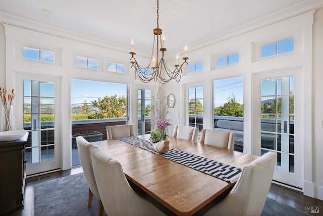 dining area featuring a chandelier, crown molding, and dark wood-type flooring