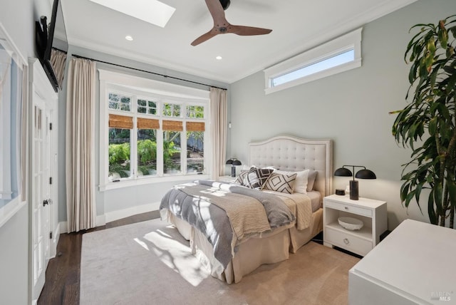 bedroom with multiple windows, a skylight, baseboards, and ornamental molding