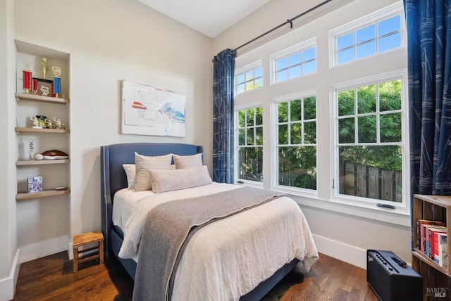 bedroom with baseboards and dark wood-style flooring