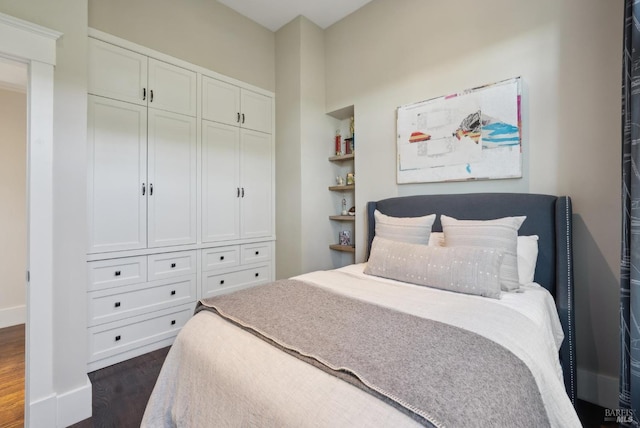 bedroom with baseboards and dark wood-type flooring